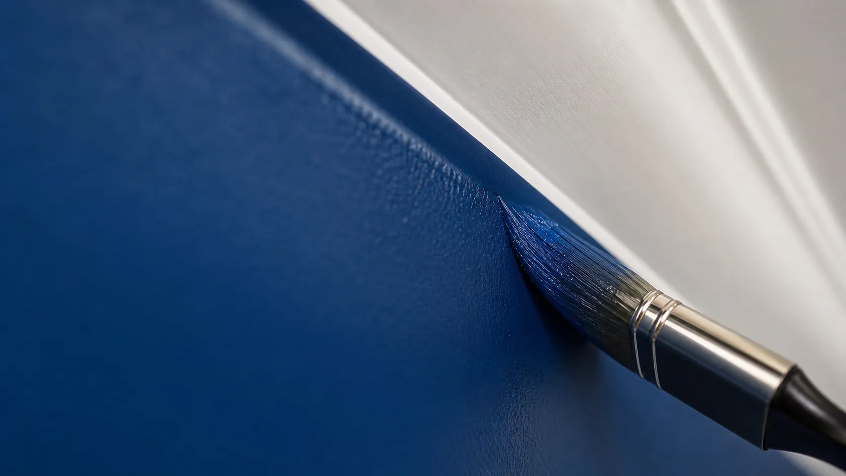 A brush cutting a clean, straight paint line where the wall meets white trim